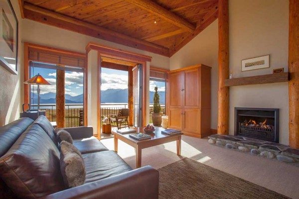 lounge room with fire place looking out window to mountain scene